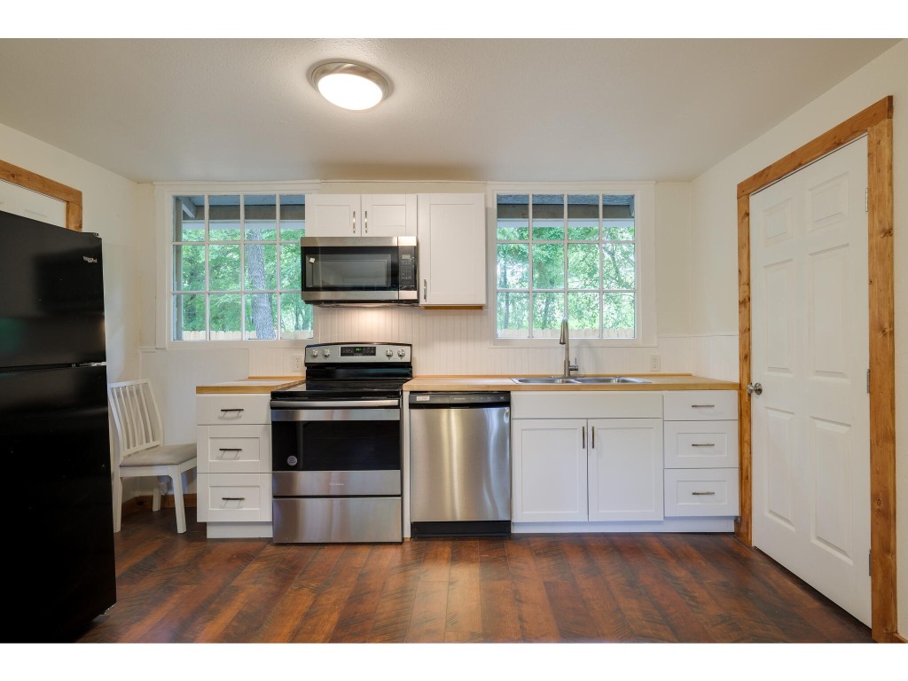 106 South Ave A, Unit E Elgin, TX 78621 - Photo 19 of 30 a kitchen with granite countertop a stove a sink and a refrigerator