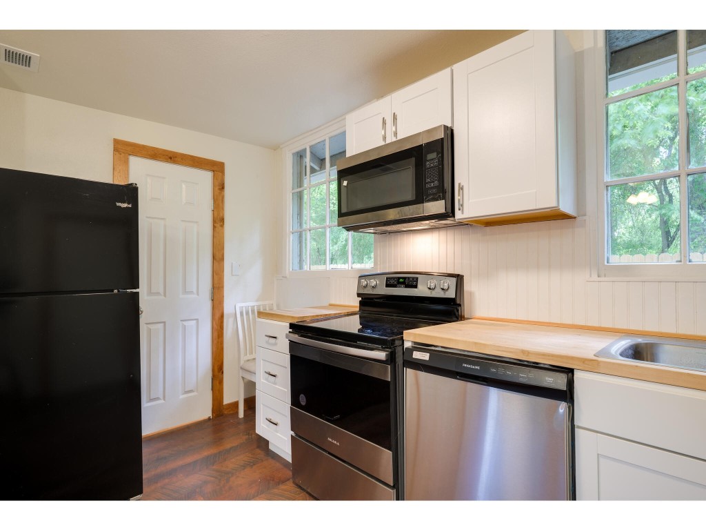 106 South Ave A, Unit E Elgin, TX 78621 - Photo 20 of 30 a kitchen with a refrigerator stove and microwave