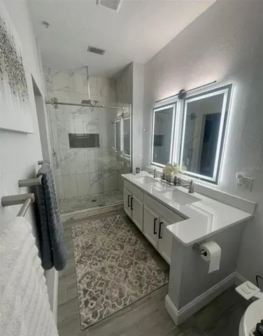 a bathroom with a double vanity sink and mirror