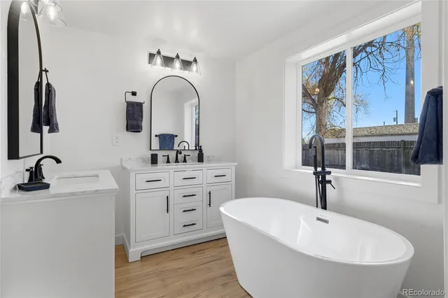 a bathroom with a tub sink and mirror