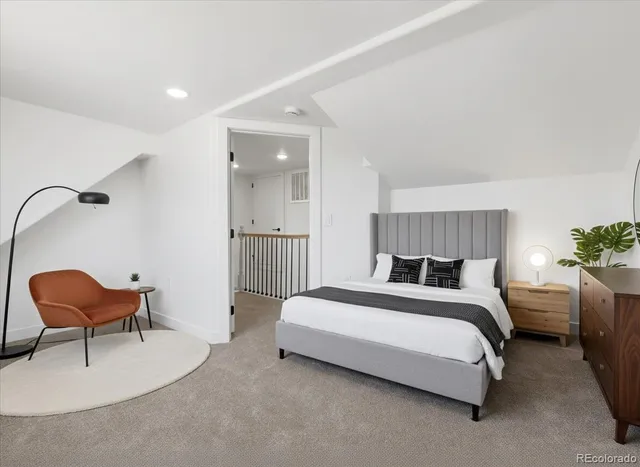 a bedroom with a bed chair and dresser