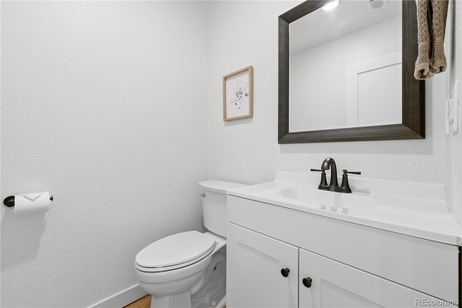 901 Garrison Street Lakewood, CO 80215 - Photo 22 of 47 a bathroom with a granite countertop toilet sink and mirror