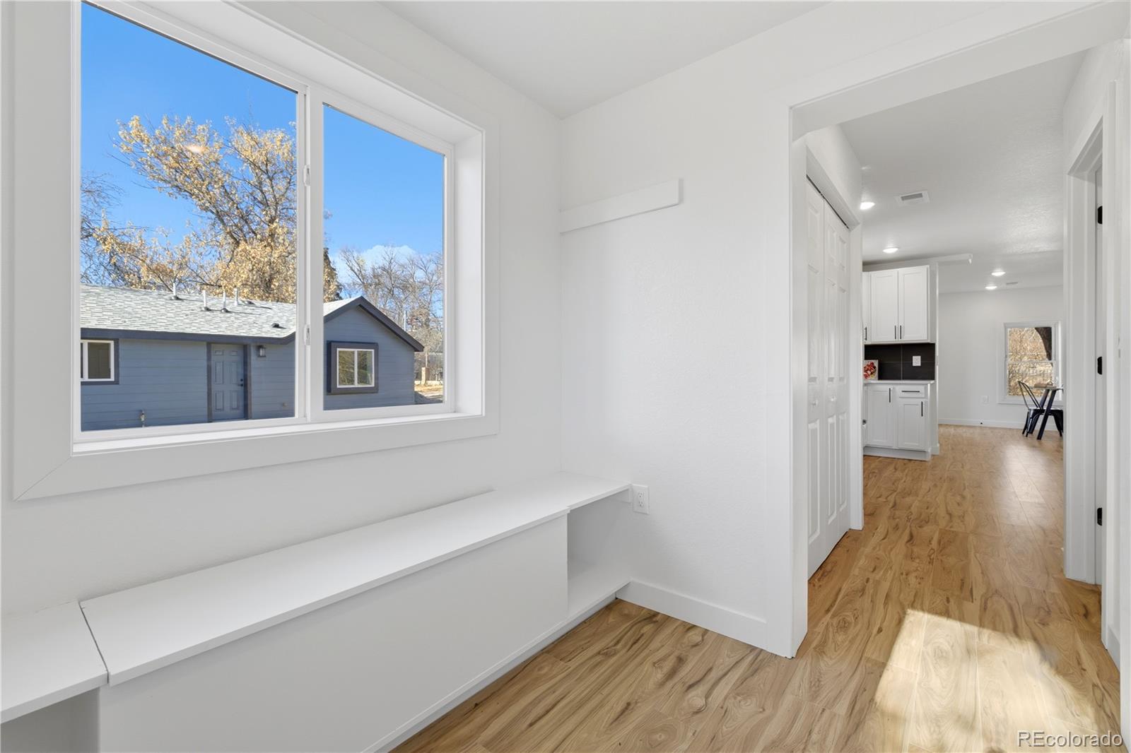 901 Garrison Street Lakewood, CO 80215 - Photo 24 of 47 a view of a hallway with wooden floor and a kitchen