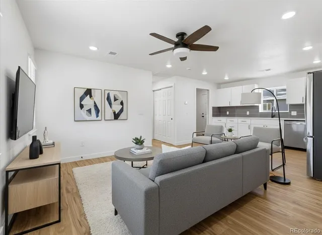 a living room with furniture and a flat screen tv with wooden floor
