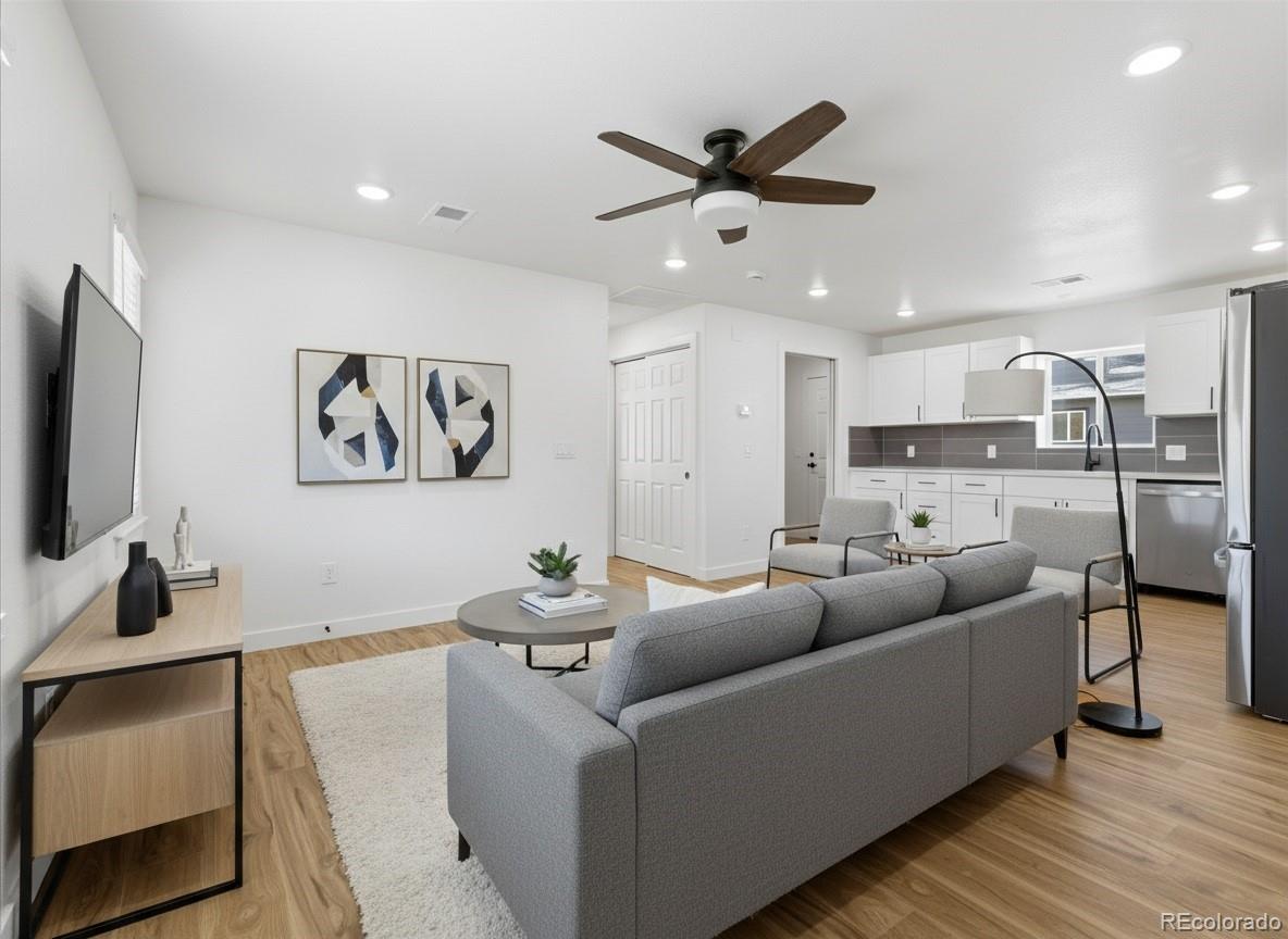 901 Garrison Street Lakewood, CO 80215 - Photo 29 of 47 a living room with furniture and a flat screen tv with wooden floor