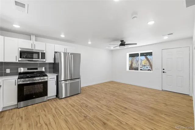 a kitchen with stainless steel appliances granite countertop a refrigerator and a stove top oven