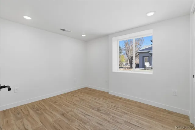 a view of empty room with wooden floor