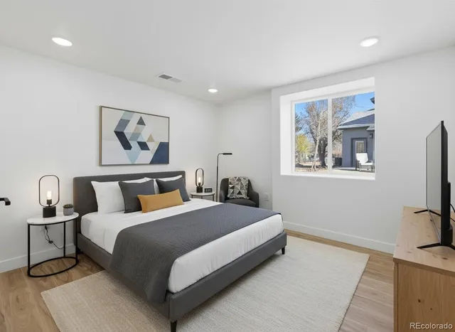 a bedroom with a large bed and a painting on the wall