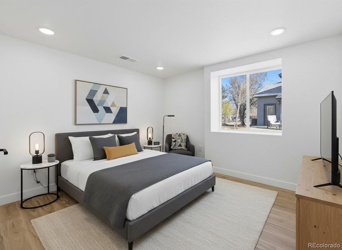 901 Garrison Street Lakewood, CO 80215 - Photo 39 of 47 a bedroom with a large bed and a painting on the wall