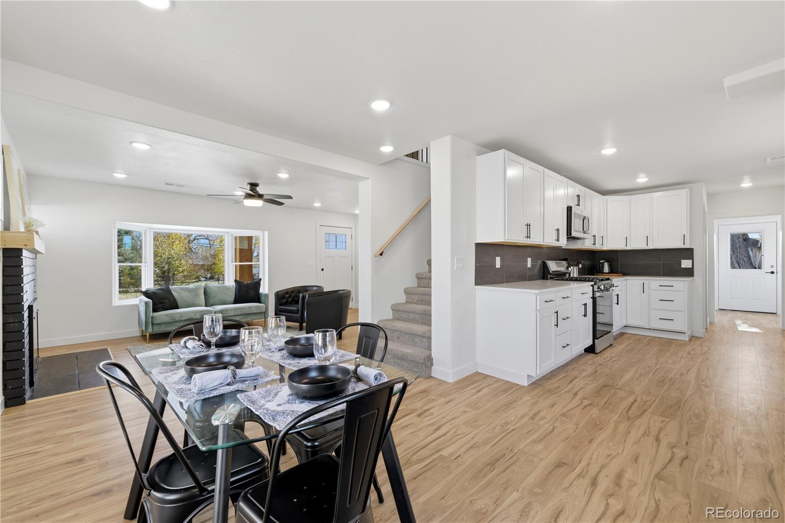 901 Garrison Street Lakewood, CO 80215 - Photo 5 of 47 a open kitchen with stainless steel appliances kitchen island granite countertop a dining table chairs and a refrigerator