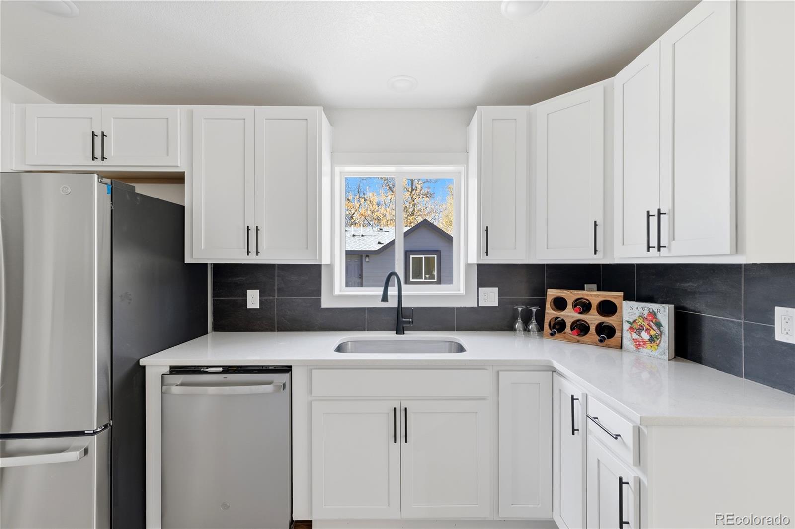 901 Garrison Street Lakewood, CO 80215 - Photo 7 of 47 a kitchen with stainless steel appliances granite countertop a sink stove and refrigerator