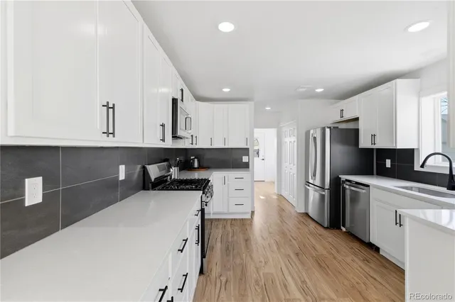 a kitchen with stainless steel appliances a refrigerator sink and cabinets