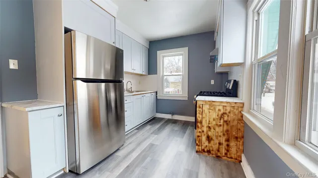 a kitchen with white cabinets and refrigerator