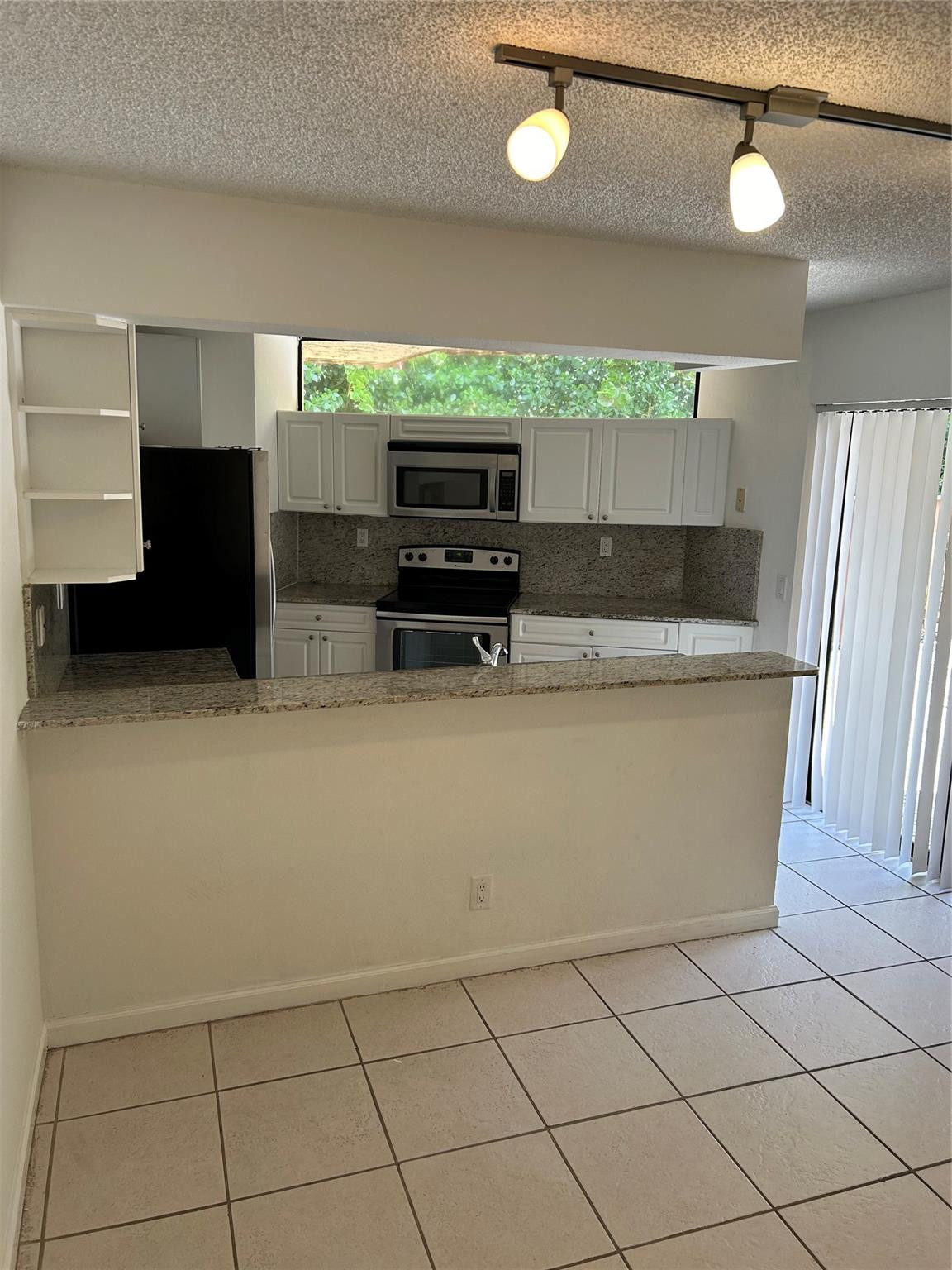 8117 Severn Drive, Unit C Boca Raton, FL 33433 - Photo 4 of 11 a kitchen with stainless steel appliances a refrigerator and a stove