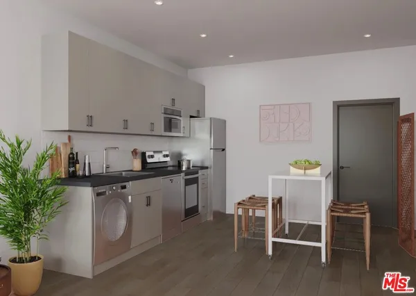a kitchen with stainless steel appliances a stove a chimney a sink and cabinets