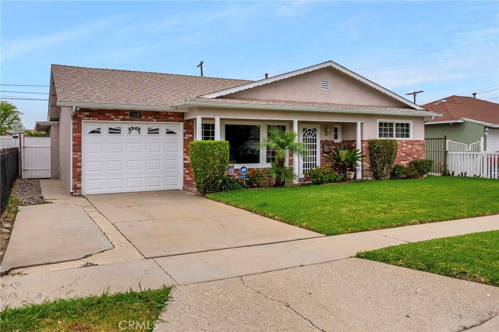 415 South Taper Avenue Compton, CA 90220 - Photo 3 of 32 a front view of a house with a garden and plants
