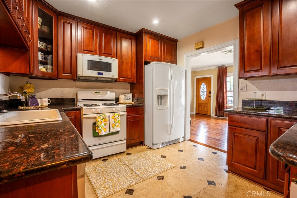 415 South Taper Avenue Compton, CA 90220 - Photo 8 of 32 a kitchen with stainless steel appliances granite countertop a stove refrigerator and cabinets