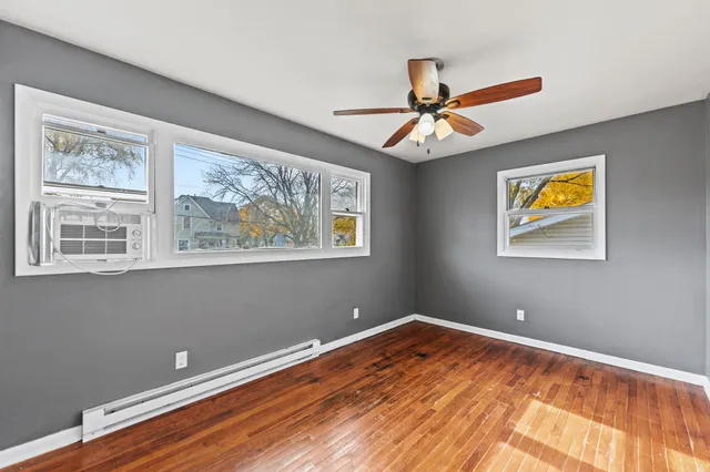 a view of room with window ceiling fan and wooden floor