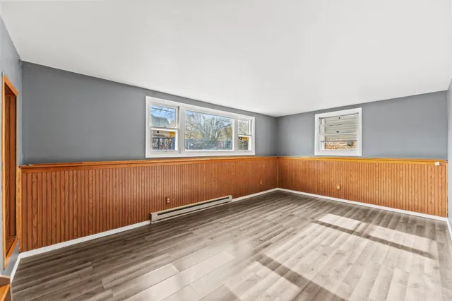 a view of a room with wooden floor and white walls