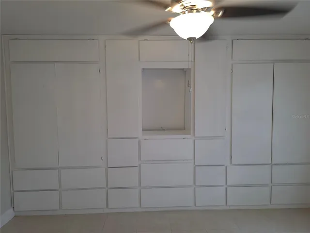 a view of a room with a chandelier fan