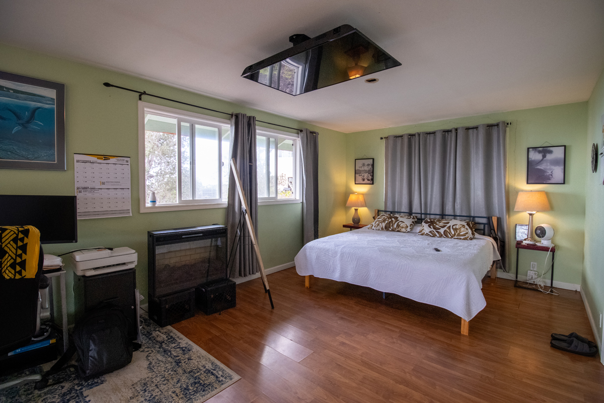 92-8901 Tiki Lane Ocean View, HI 96704 - Photo 14 of 24 a bedroom with a bed and wooden floor