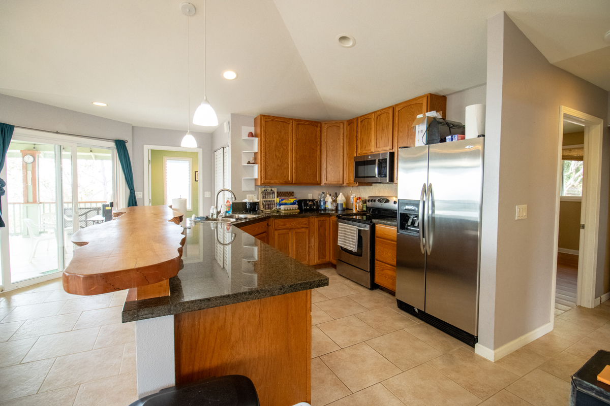 92-8901 Tiki Lane Ocean View, HI 96704 - Photo 19 of 24 a kitchen with stainless steel appliances granite countertop a refrigerator a stove and a sink
