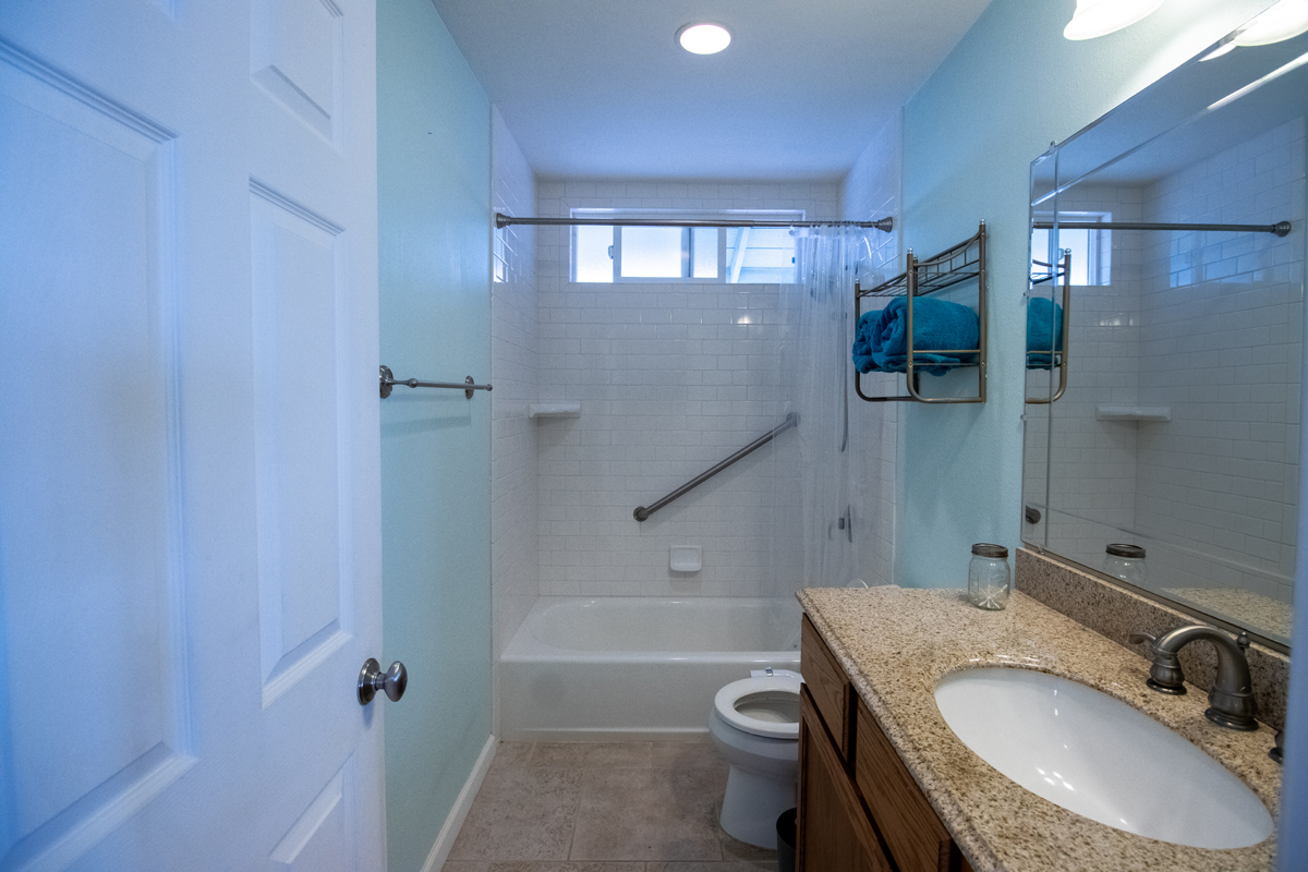 92-8901 Tiki Lane Ocean View, HI 96704 - Photo 22 of 24 a bathroom with a granite countertop sink toilet and shower