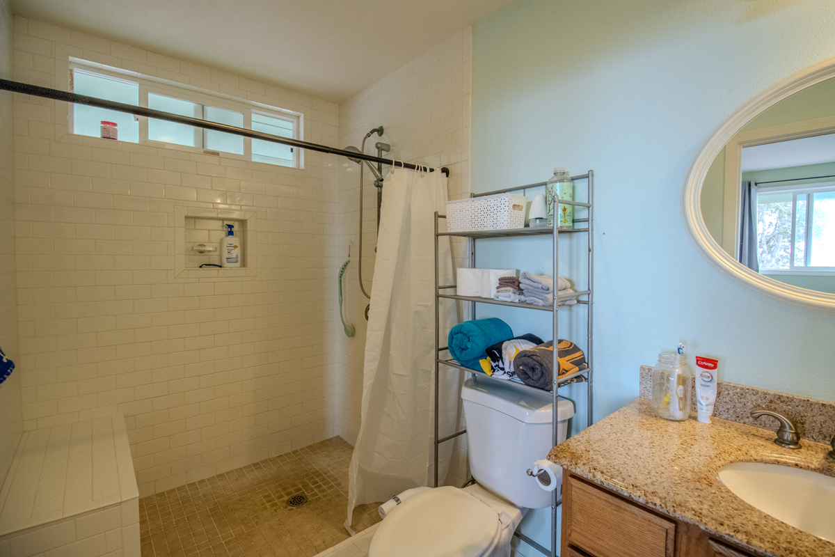 92-8901 Tiki Lane Ocean View, HI 96704 - Photo 24 of 24 a bathroom with a granite countertop sink toilet and shower