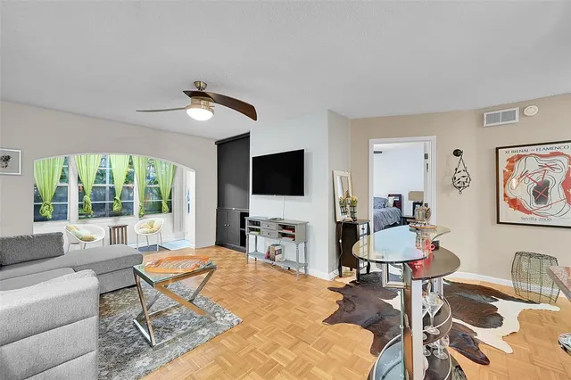 a living room with furniture a flat screen tv and a large window