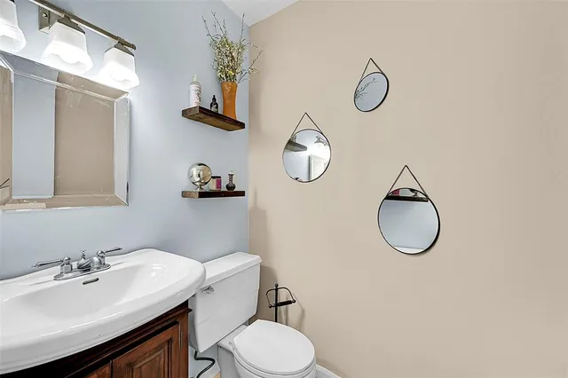 a bathroom with a toilet a sink and mirror