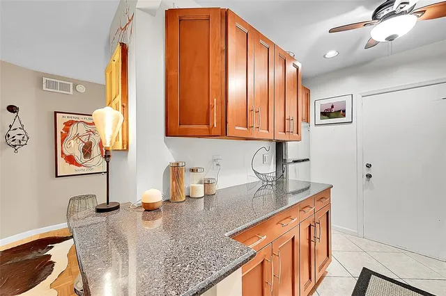 a kitchen with stainless steel appliances granite countertop a sink window and cabinets
