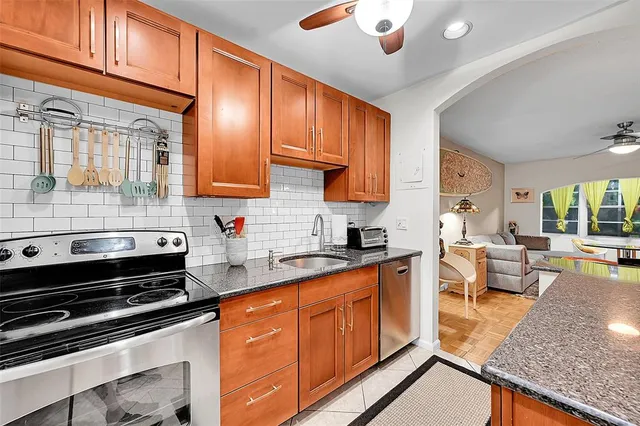 a kitchen with stainless steel appliances granite countertop wooden cabinets a stove top oven a sink and dishwasher