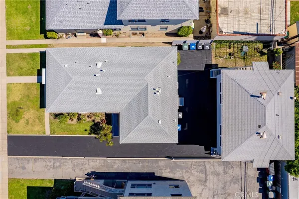 an aerial view of residential houses with outdoor space and parking