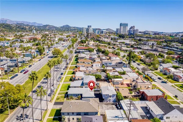 an aerial view of residential houses with outdoor space and trees