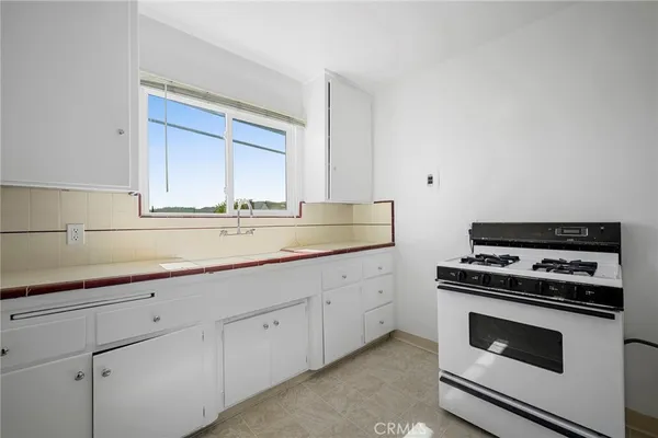 a kitchen with white cabinets and appliances
