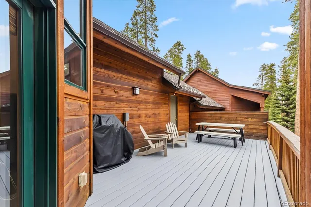 a view of a two chairs and table in the balcony with wooden floor