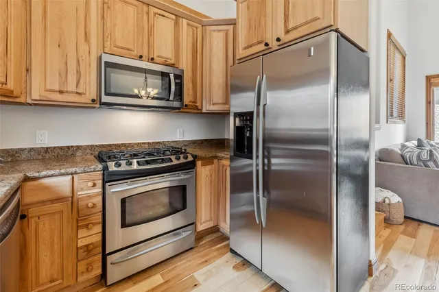 a metallic refrigerator freezer sitting inside of a kitchen
