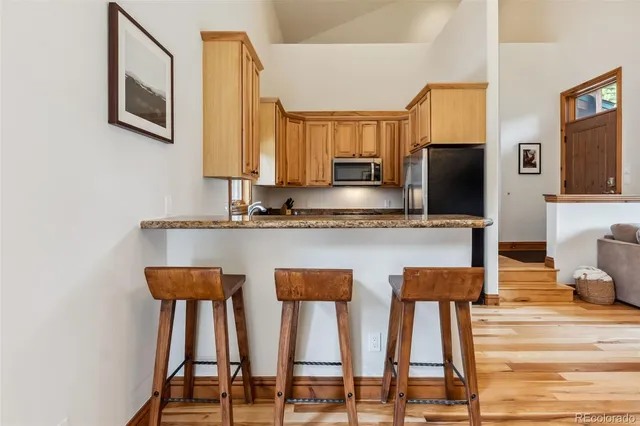 a kitchen with stainless steel appliances kitchen island granite countertop a refrigerator and microwave