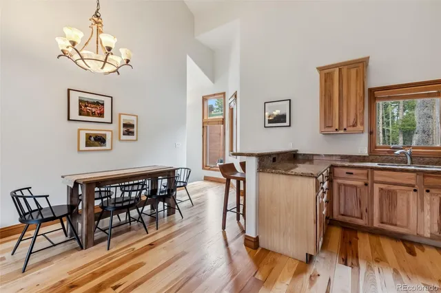 a kitchen with a table chairs stove and wooden floor