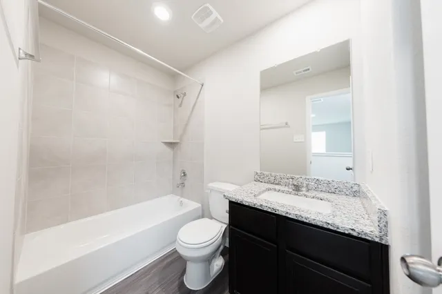 a bathroom with a granite countertop sink toilet and shower