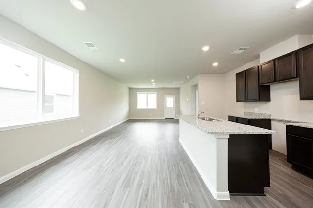 a kitchen with granite countertop a sink a counter space appliances and cabinets