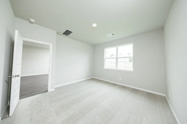 an empty room with windows and closet