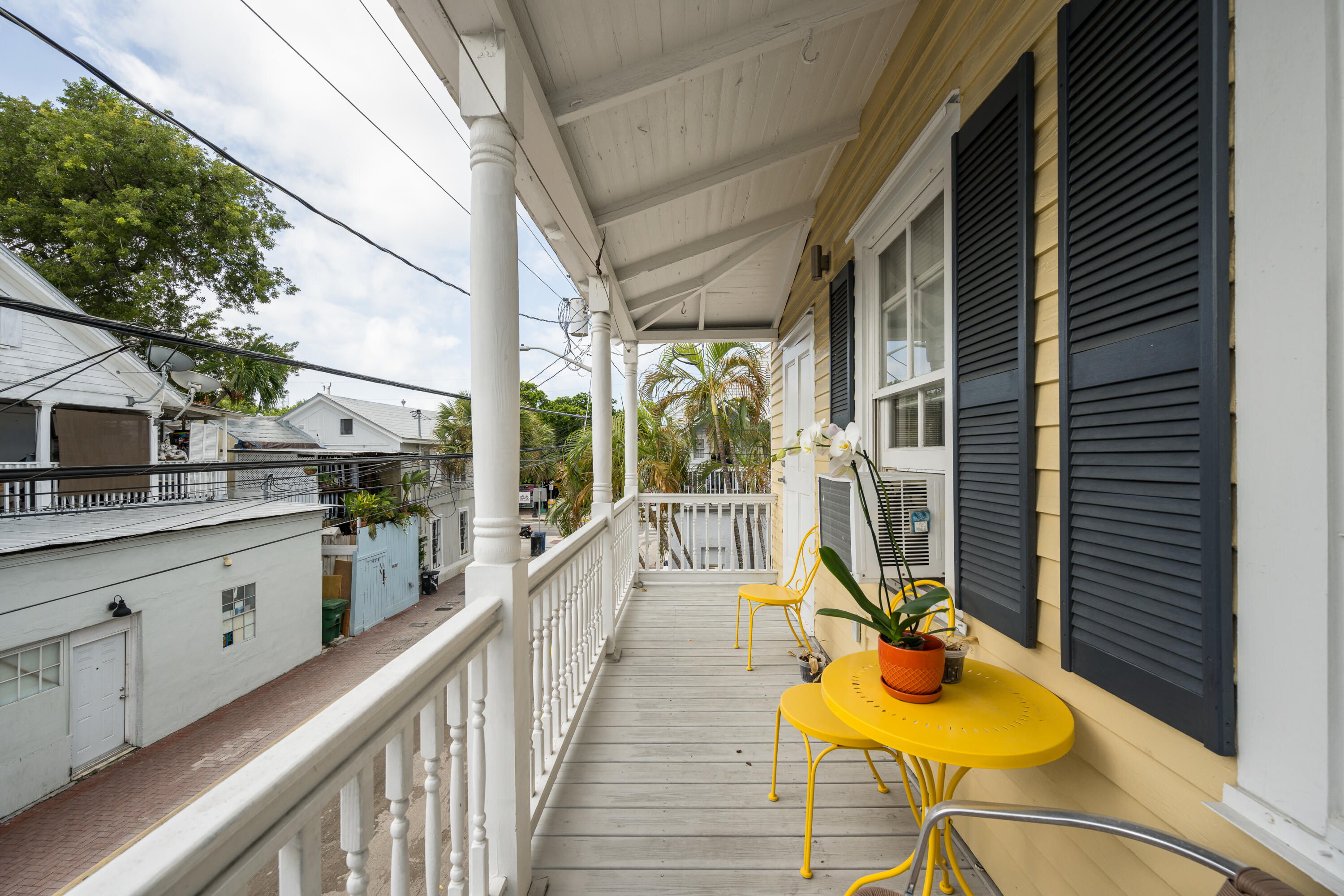 405 Petronia Street Key West, FL 33040 - Photo 21 of 47 a view of a balcony with wooden floor and a potted plant