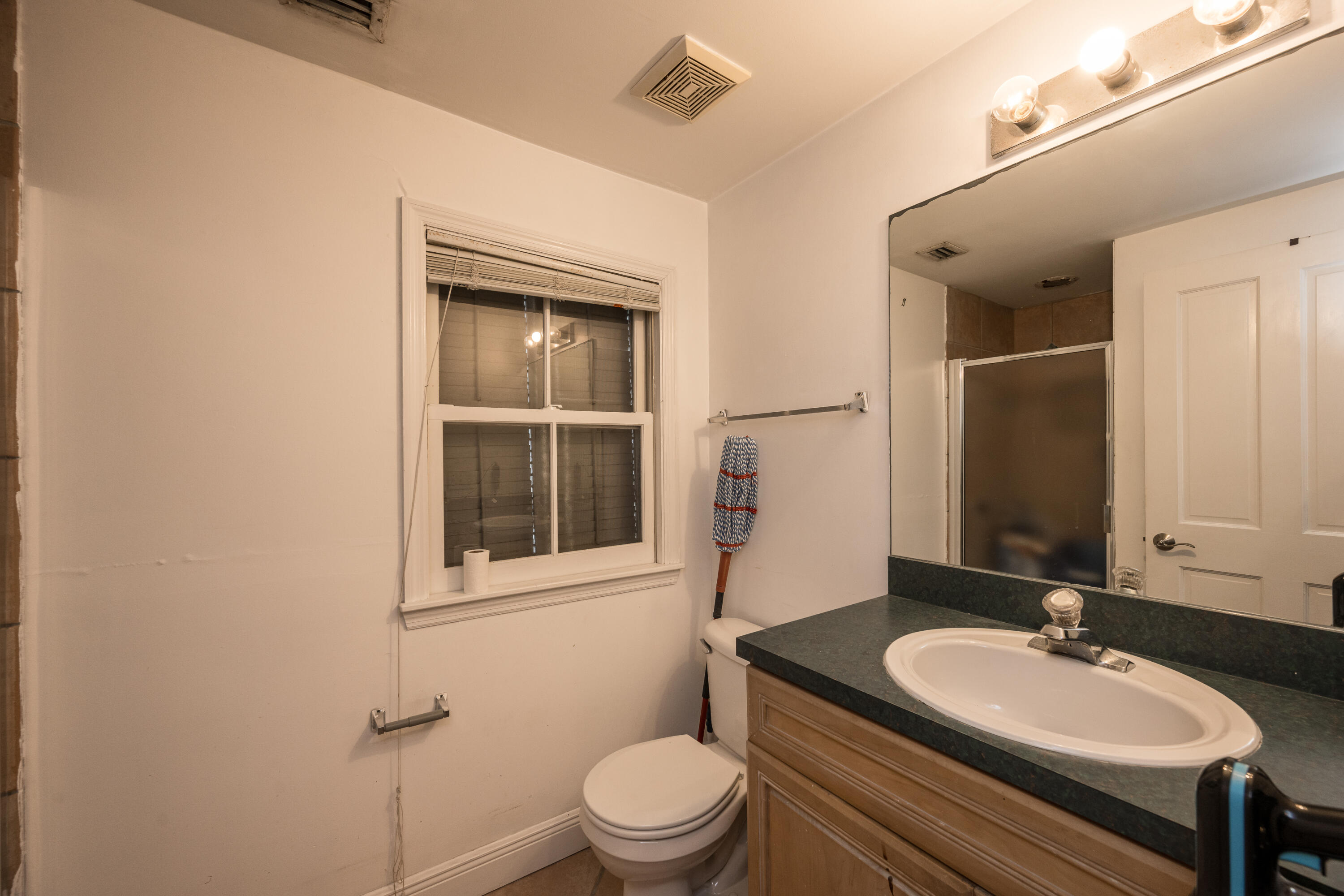 405 Petronia Street Key West, FL 33040 - Photo 22 of 47 a bathroom with a granite countertop toilet a sink and a mirror