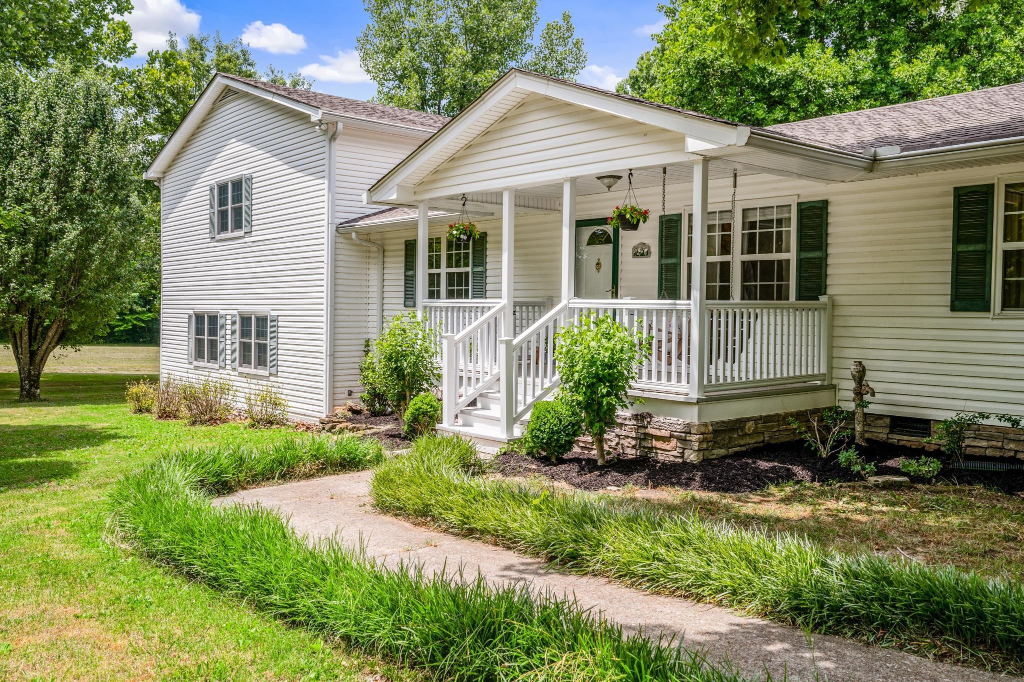 a front view of a house with a yard and potted plants