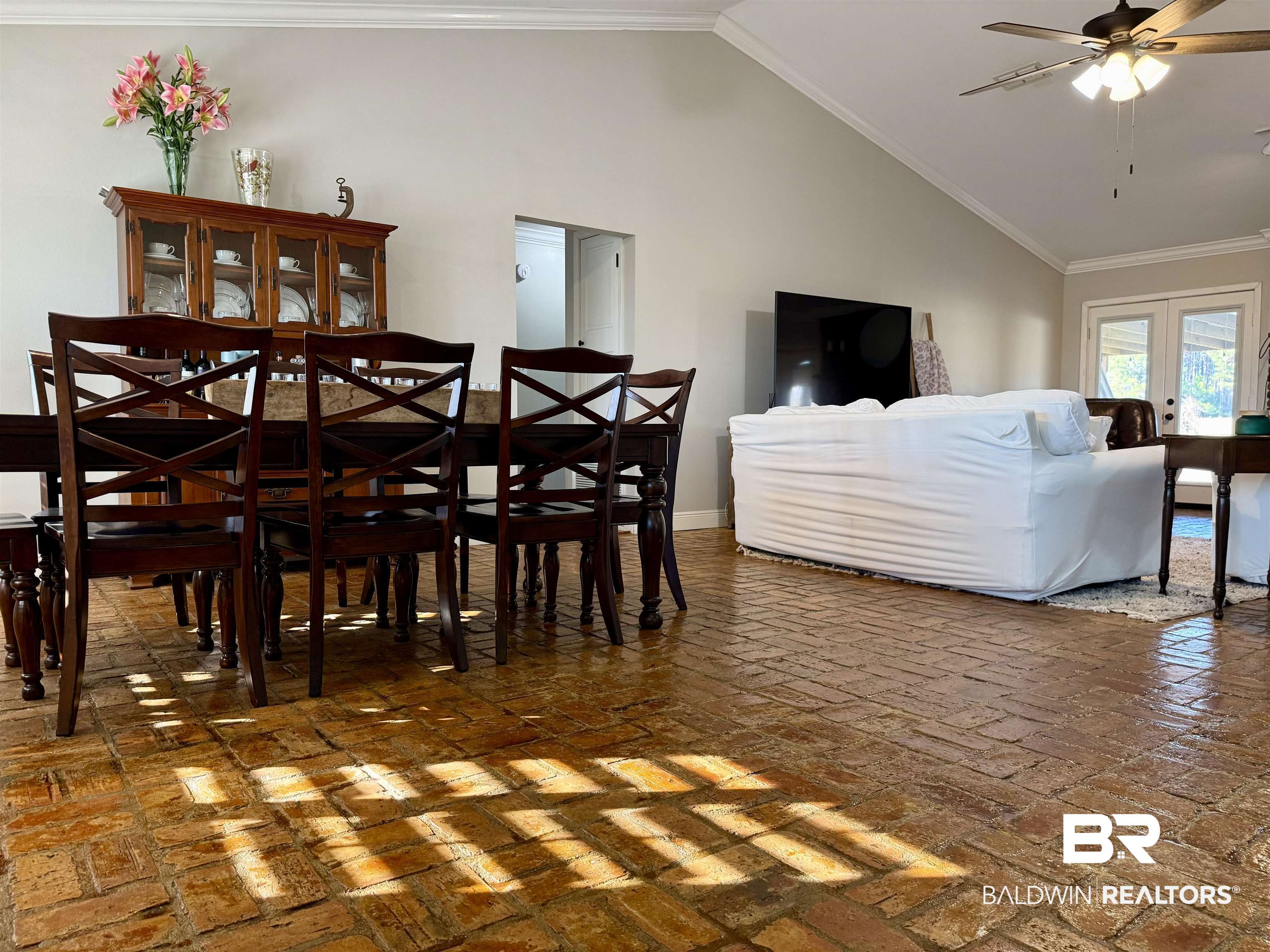 5646 Foshee Road Brewton, AL 36426 - Photo 11 of 37 Dining room featuring a ceiling fan, crown molding, lofted ceiling, brick flooring, and french doors