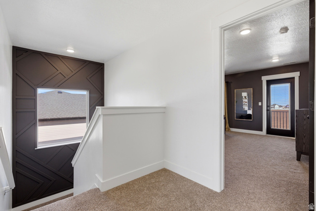 3902 West 825 North West Point, UT 84015 - Photo 9 of 49 Hall with an upstairs landing, light carpet, and a textured ceiling