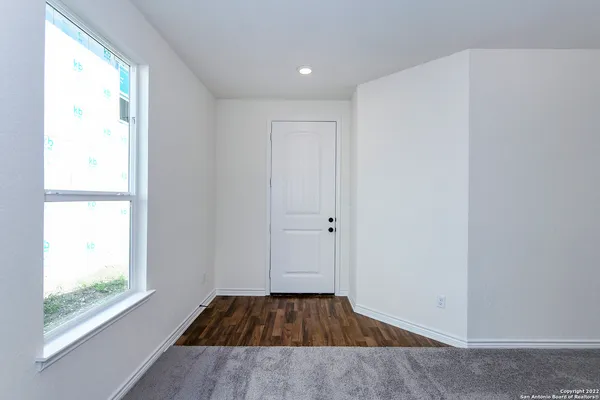 a view of a room with wooden floor and window