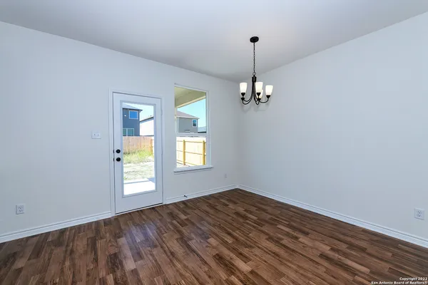 a view of empty room with window and chandelier