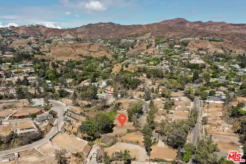 an aerial view of residential houses with outdoor space and trees